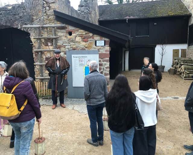 Zum Start der Führung versammelt sich die Gruppe um den Burgführer vor einer Übersichtstafel auf der Unterburg.
